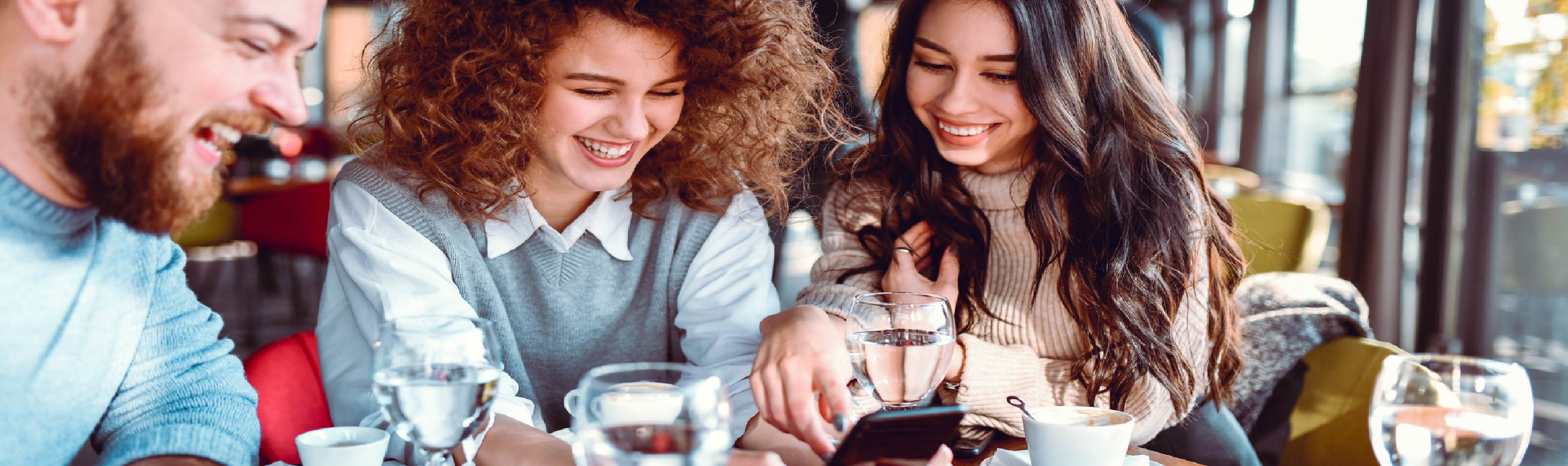 A group of friends looking at a cell phone
